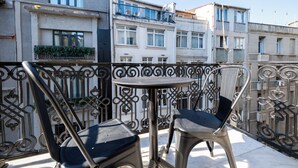 A balcony with two chairs and a small round table, overlooking a row of buildings. - Balo (Istanbul)