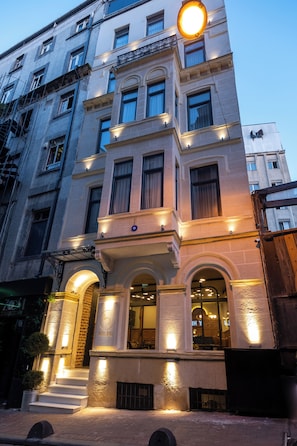 A multi-story hotel with a grand entrance, large windows, and a well-lit facade. - Balo (Istanbul)