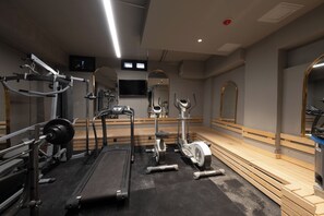 A gym with cardio equipment, weight machines, and a mirror. - Balo (Istanbul)