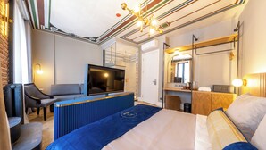 A modern hotel room with a large bed, a TV, a desk, and a seating area. - Balo (Istanbul)
