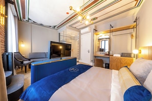 A modern hotel room with a large bed, a TV, a desk, and a seating area. - Balo (Istanbul)