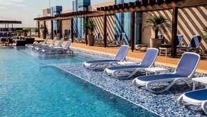 A poolside area with lounge chairs and a tiled pool.