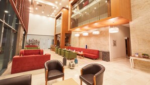 A spacious lobby with multiple seating areas, a reception desk, and a visible restroom sign. - Park Dedeman Denizli (Denizli)