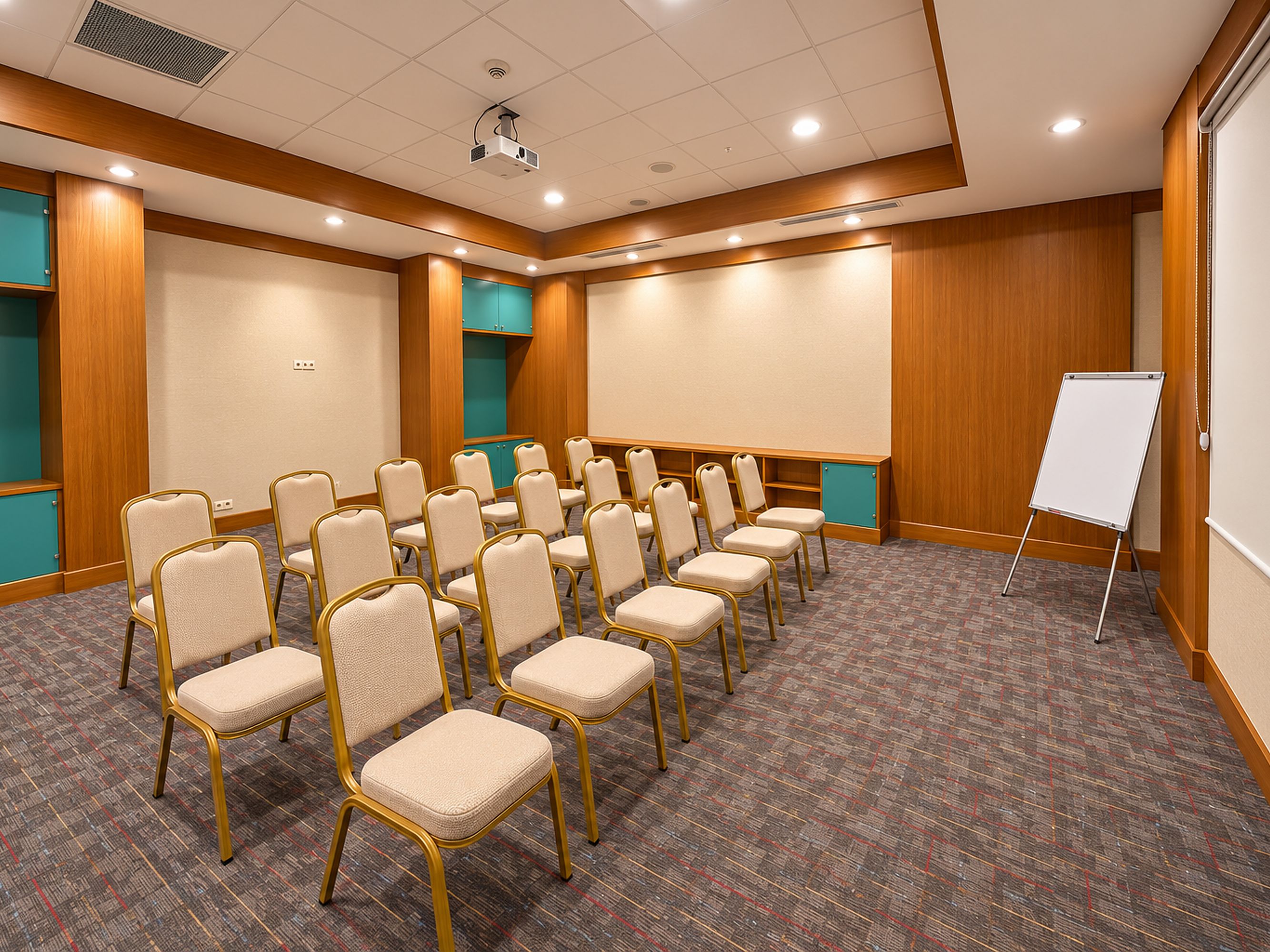 A conference room with rows of chairs, a whiteboard, and a carpeted floor.