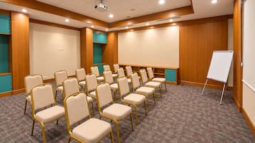 A conference room with rows of chairs, a whiteboard, and a carpeted floor.