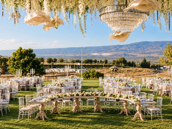 An outdoor wedding venue with round tables, white chairs, and floral arrangements. - Park Dedeman Denizli (Denizli)