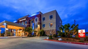Een Best Western Plus hotel met een modern design, met een overdekte ingang en een aangelegde voortuin met palmboompjes.