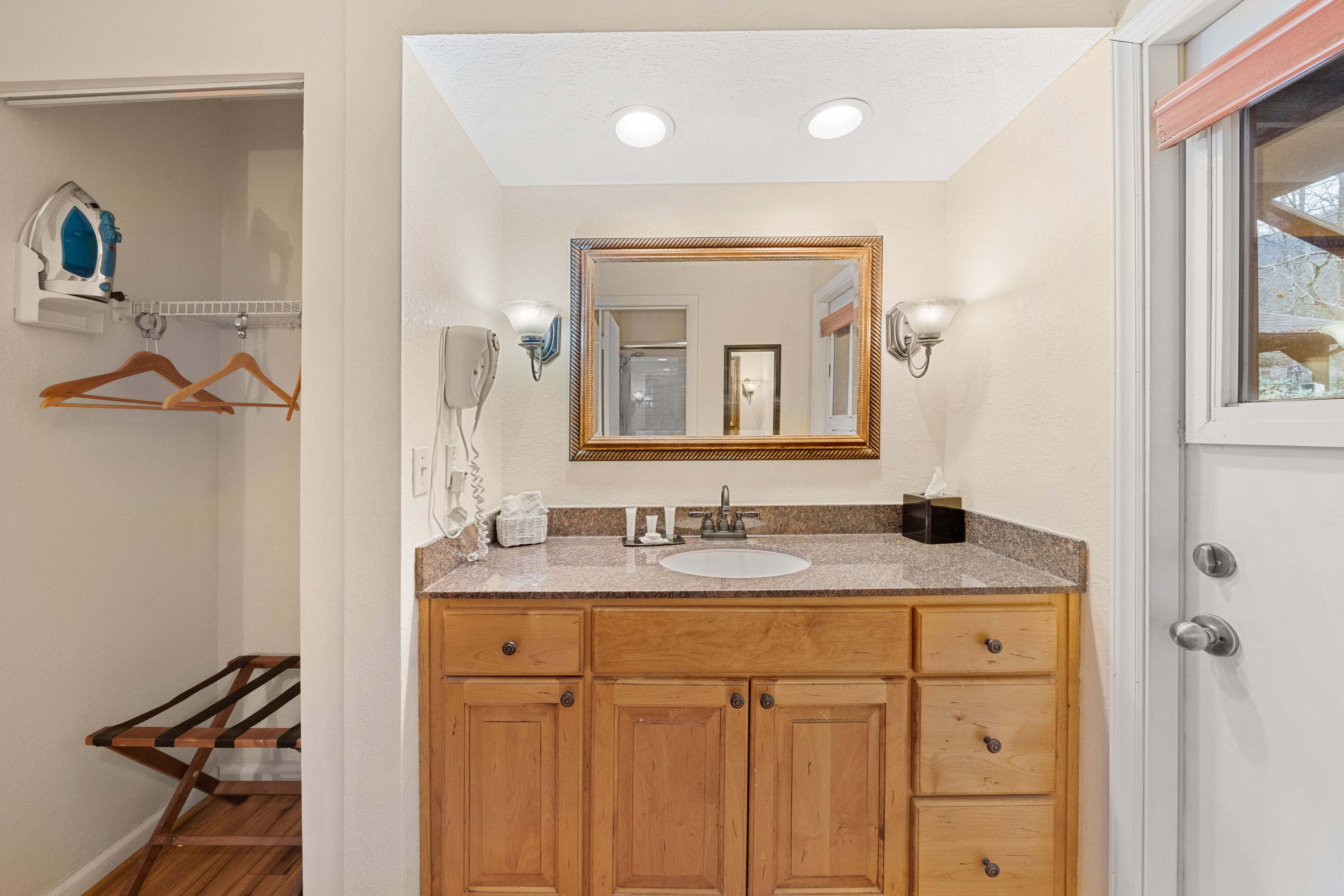 A bathroom with wooden cabinets, a sink, a mirror, and a towel rack.