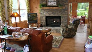 A cozy living room with a fireplace, leather sofa, and a television.