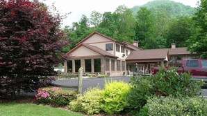 A two-story building with a brick facade, a covered porch, and a parking lot.