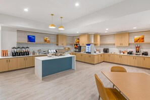 Une cuisine moderne avec des meubles en bois, un îlot central et divers appareils électroménagers.