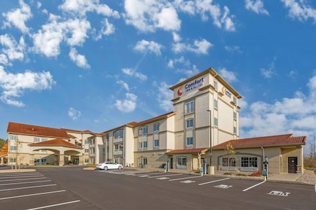 A hotel with a sign reading 'Comfort Inn & Suites,' a parking lot, and a clear blue sky.. Comfort Inn & Suites Verona at Turning Stone Resort Casino