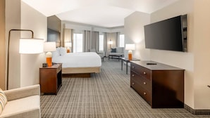 A hotel room with a bed, a desk, a chair, a television, and a lamp. - Comfort Inn & Suites Verona at Turning Stone Resort Casino (Verona)