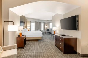 Une chambre d’hôtel équipée d’un lit, d’un bureau, d’une chaise, d’une télévision et d’une lampe.