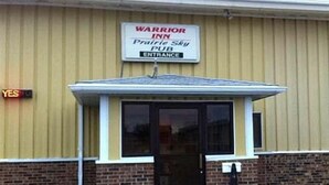 A building with a sign that reads "WARRIOR INN Prairie Ski Pub Entrance."