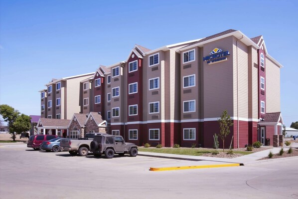 A multi-story hotel with a maroon and beige facade, featuring a prominent "Nick Hotel" sign.
