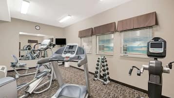 A hotel gym with treadmills, elliptical machines, and weight machines.