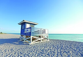 A beach lifeguard tower with a clear view of the ocean.