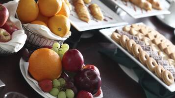A table with a variety of fruits and pastries.