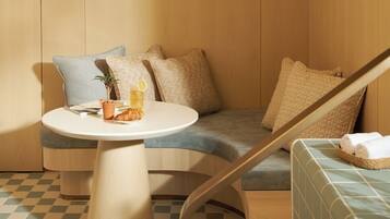 A modern room with a checkered floor, a round table, a sofa, and a hanging lamp.