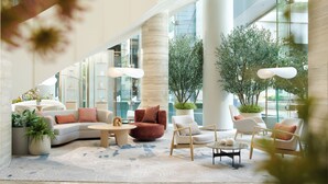 A modern lobby with seating arrangements, large windows, and indoor plants. - The Royal Garden Kowloon East (Sai Kung)