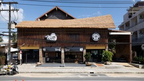 A building with a thatched roof and a sign reading "Wing". - Motive Cottage Resort (Takua Pa)