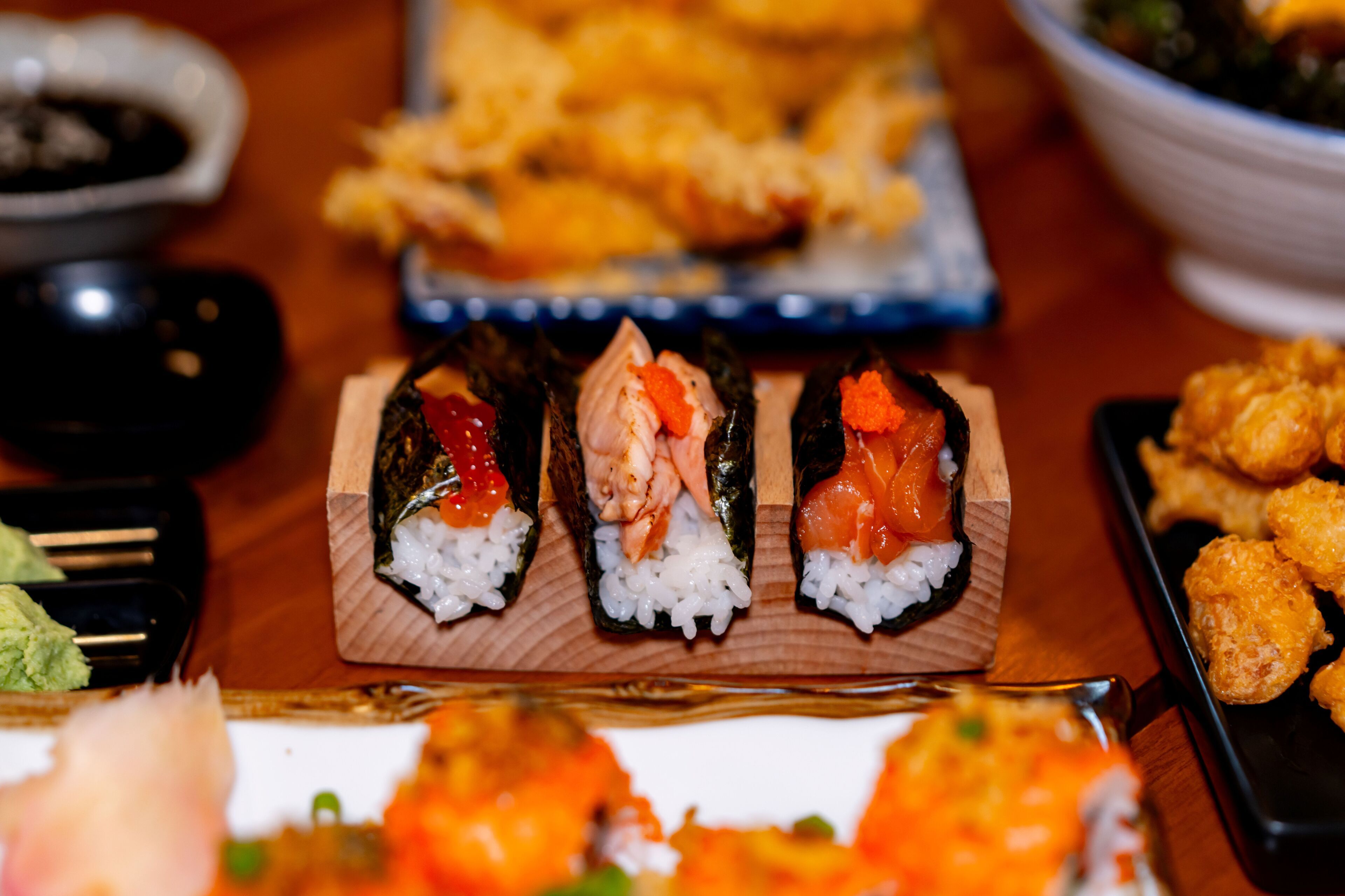 A sushi platter with various types of sushi on a wooden board.