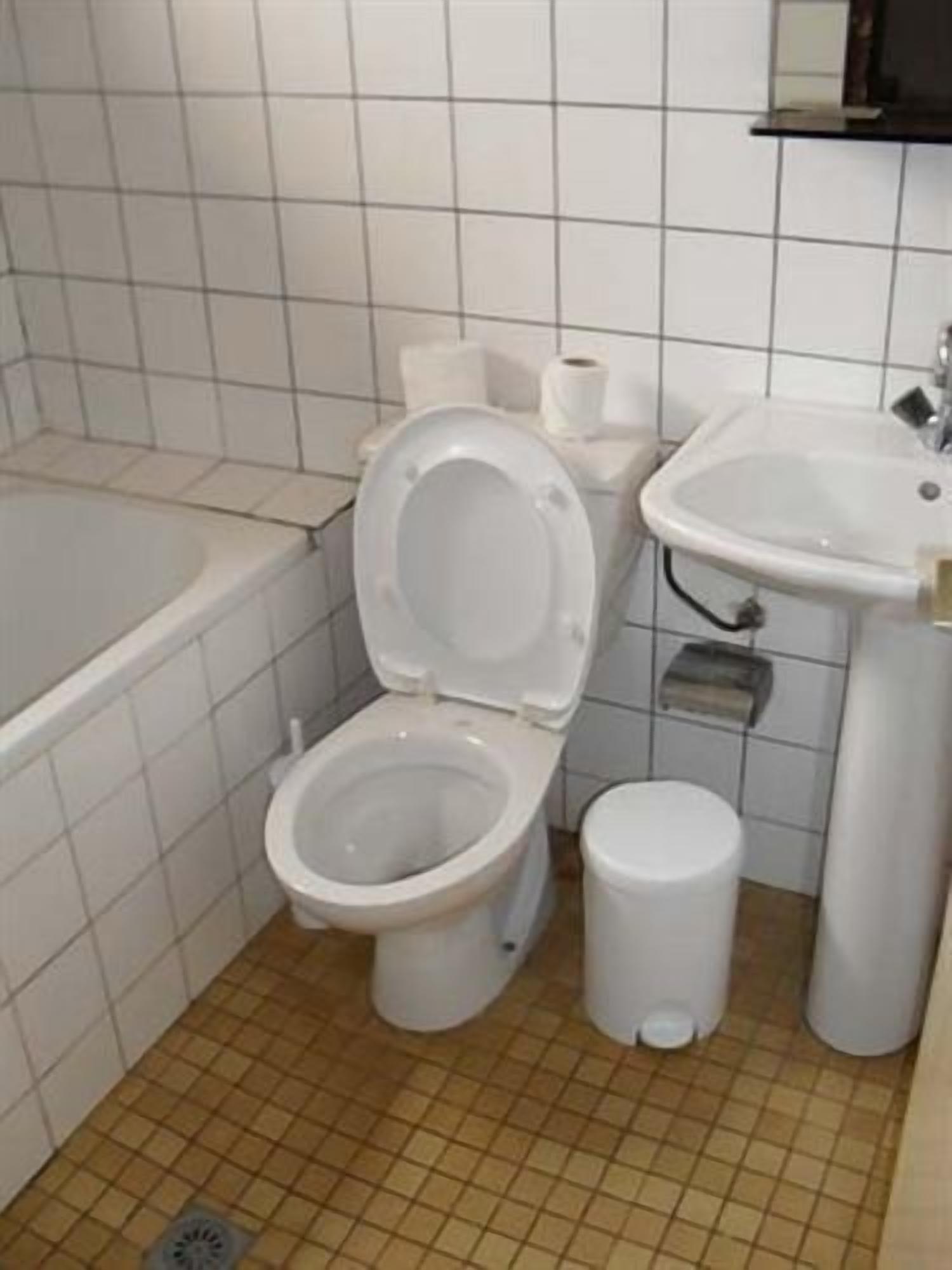 A bathroom with a toilet, sink, and bathtub.