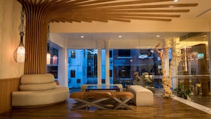 Un interior moderno con techo de madera, una zona de estar con banco y una pared de vidrio que ofrece vistas al exterior.