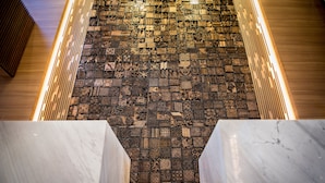 Una escalera con un papel tapiz decorado y piso de madera.
