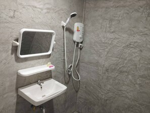 A bathroom with a white sink, a mirror, and a handheld showerhead. -  The Relax Beach Resort (Ko Pha-ngan)
