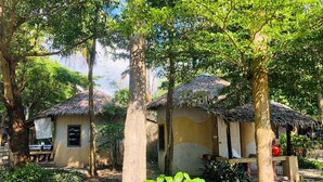 A rustic thatched-roof structure with a simple, functional design, surrounded by lush greenery and trees. -  The Relax Beach Resort (Ko Pha-ngan)