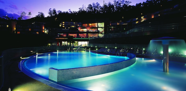 Een binnenzwembad, een buitenzwembad en parasols bij het zwembad