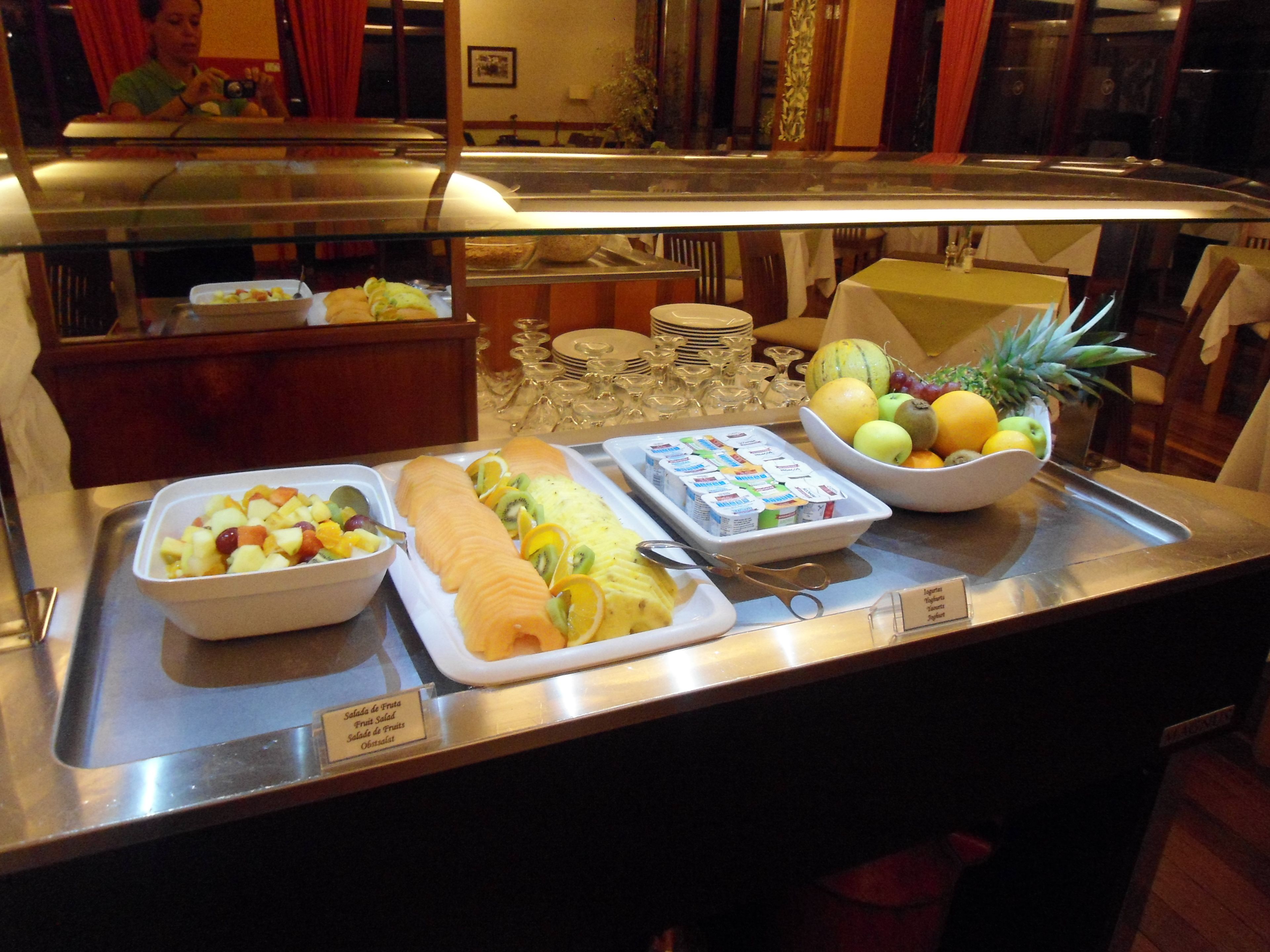 A buffet with various fruits and a salad.