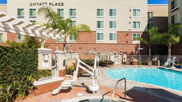 Relax by the pool surrounded by comfortable lounge chairs and shaded areas.