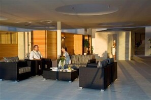 Een ruime lobby met modern meubilair en een centrale salontafel.
