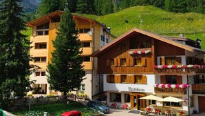 Ein Hotel mit mehreren Etagen, Balkonen mit Blumenkästen und einem Schild mit der Aufschrift "Geviztana".
