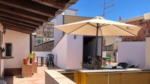 A covered outdoor area with a pool, seating, and a view of the city. - Populus (Syracuse)