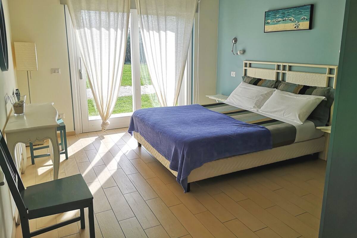 A bedroom with a bed, a desk, and a chair.