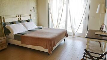 A neatly arranged bedroom with a bed, a desk, and a chair.