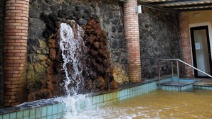A water feature with a waterfall, stone walls, and a glass ceiling with colorful panels. - Hotel San Valentino (Ischia)