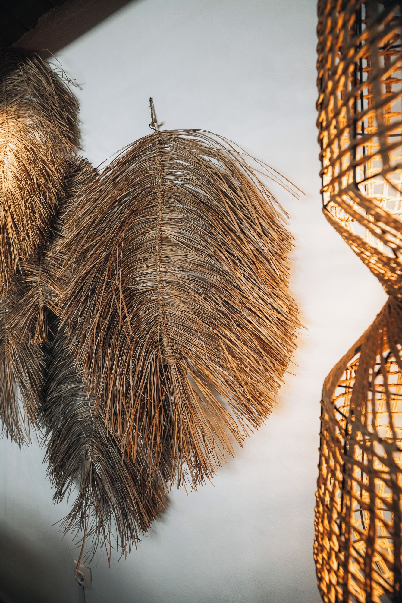 Een close-up van een geweven, ronde lamp met een natuurlijke, vezelachtige textuur.