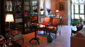Una sala de estar acogedora con chimenea, una estantería y asientos cómodos.