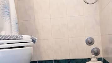 Bañera profunda, cabezal de ducha tipo lluvia, secador de pelo, toallas