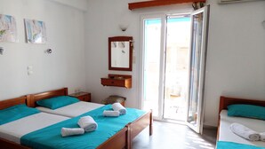 A hotel room with two beds, a bathroom, and a sliding glass door to the outside. - Rea Sun Hotel Studios Apartments (Naxos)