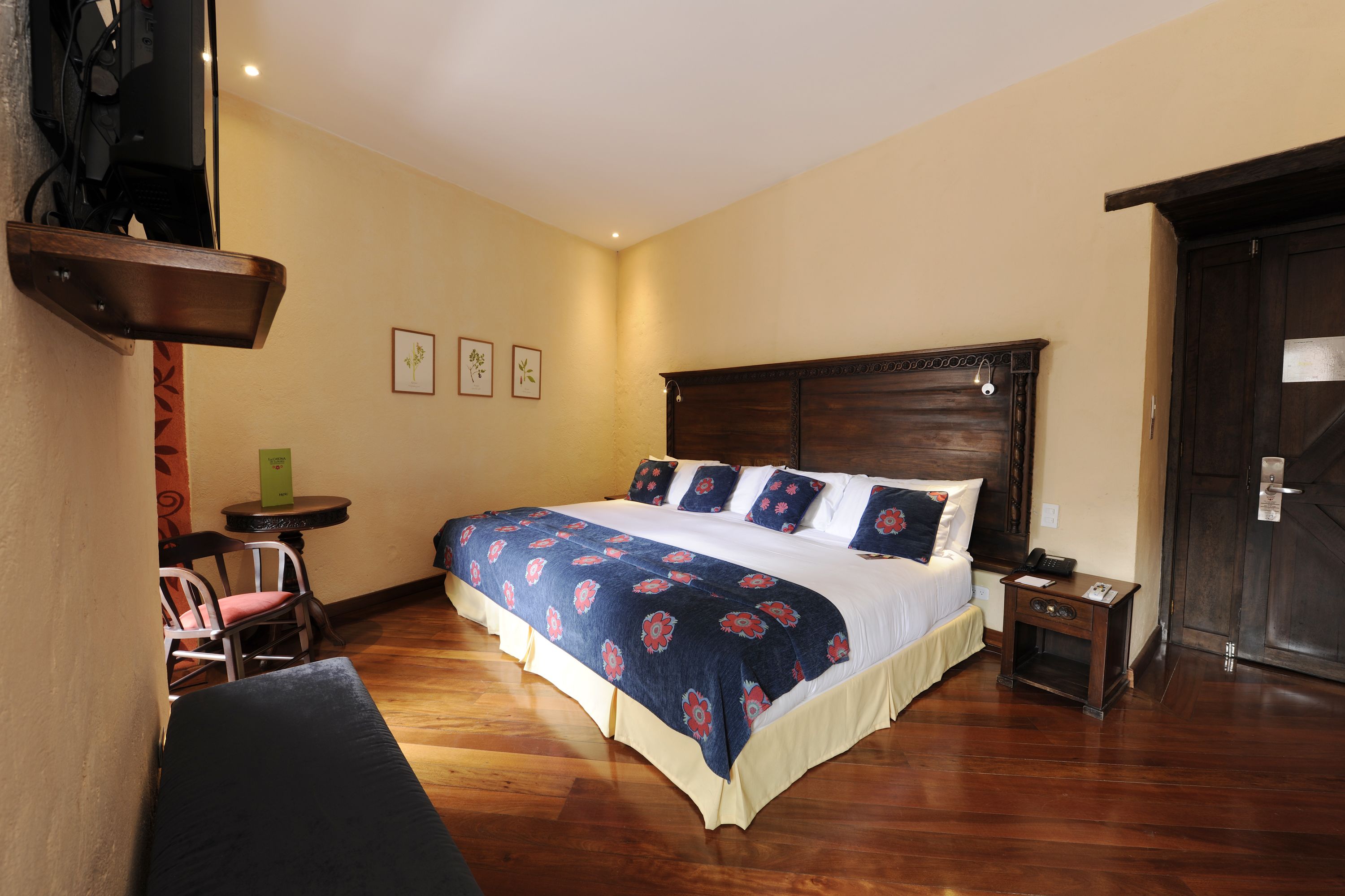 A neatly arranged bedroom with a large bed, bedside tables, and a chair.