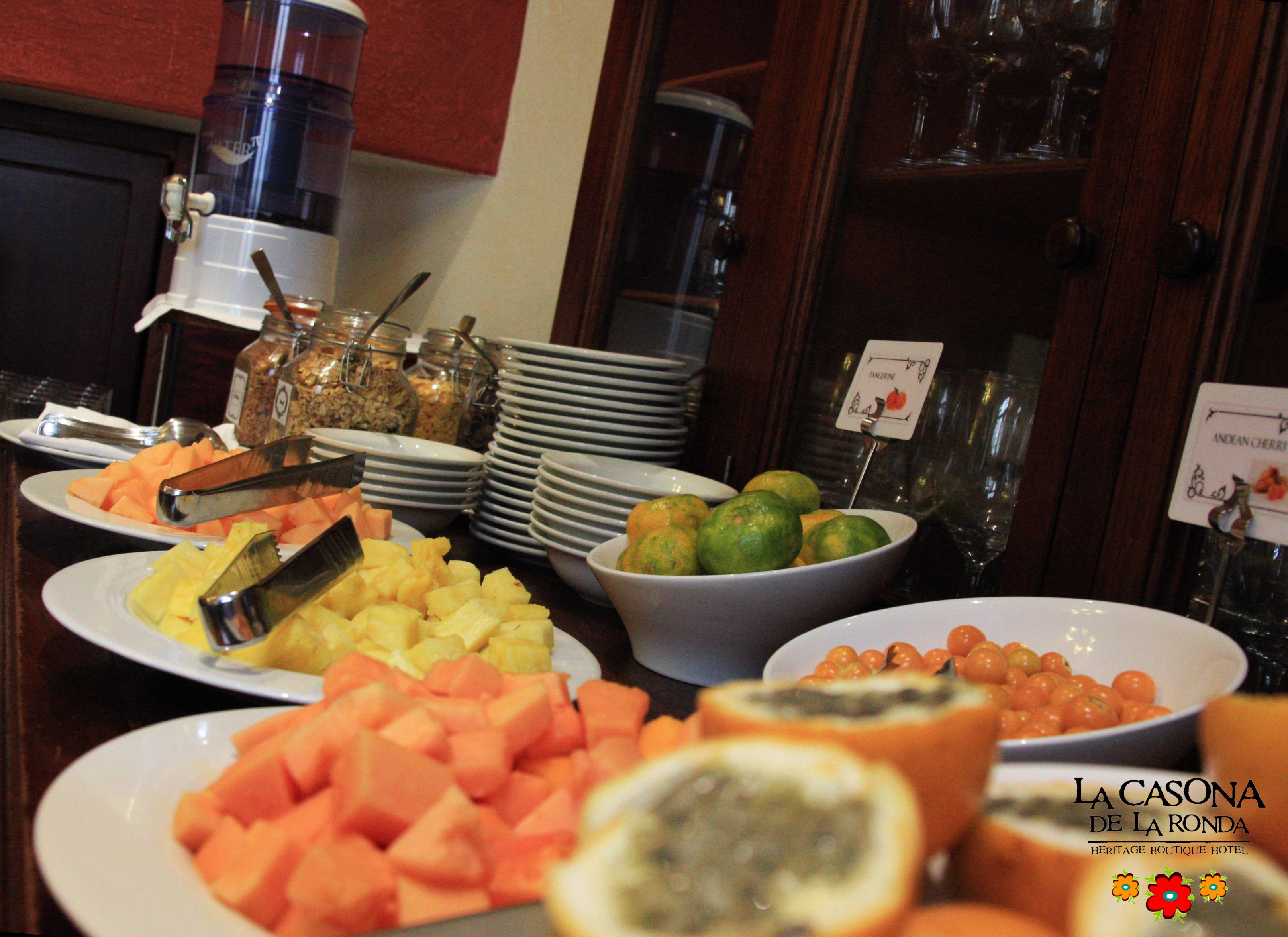 A buffet with various fruits and a sign for La Casona de La Ronda Heritage Boutique Hotel.