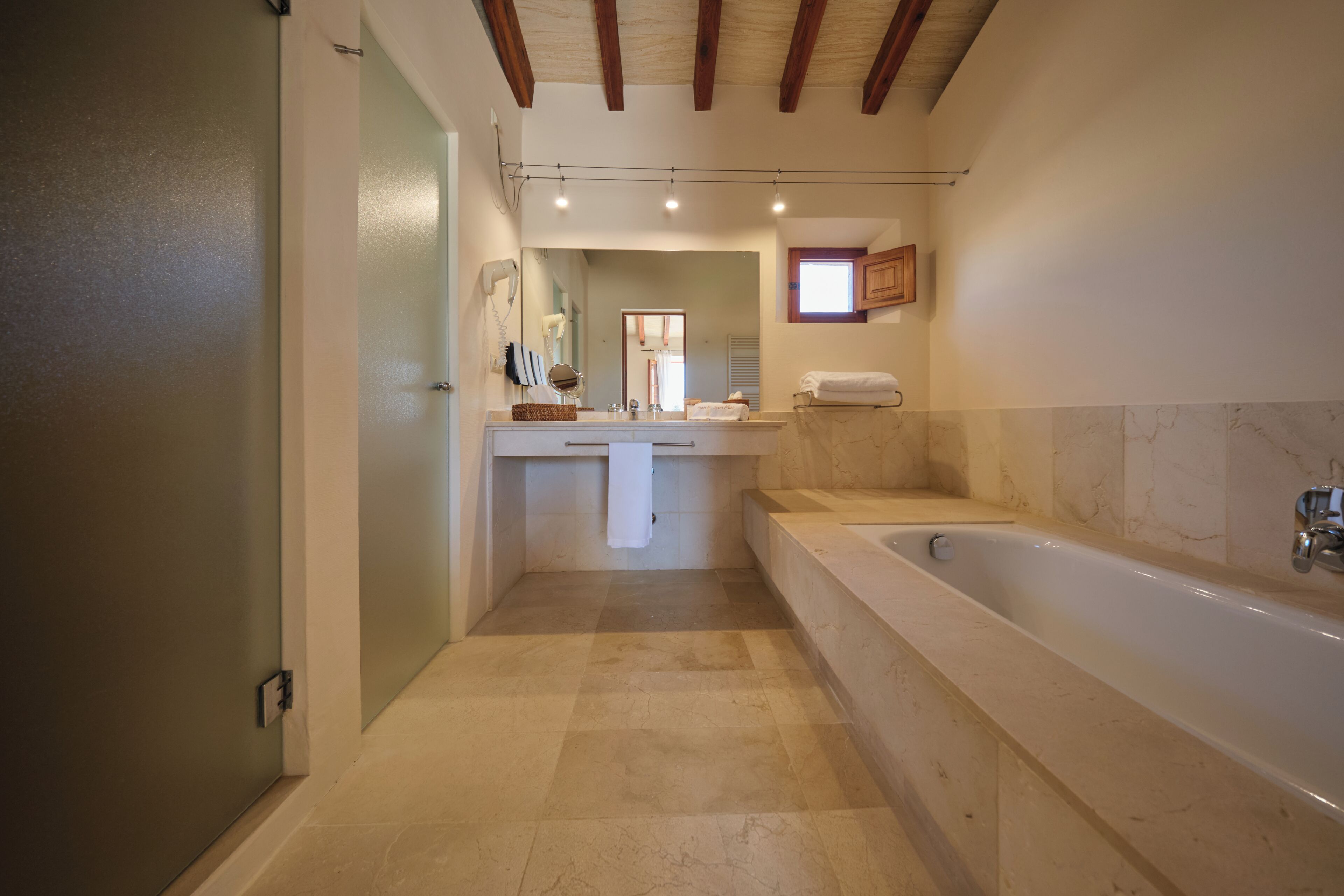 Une salle de bain avec une baignoire, un meuble-lavabo avec un miroir et un porte-serviettes.