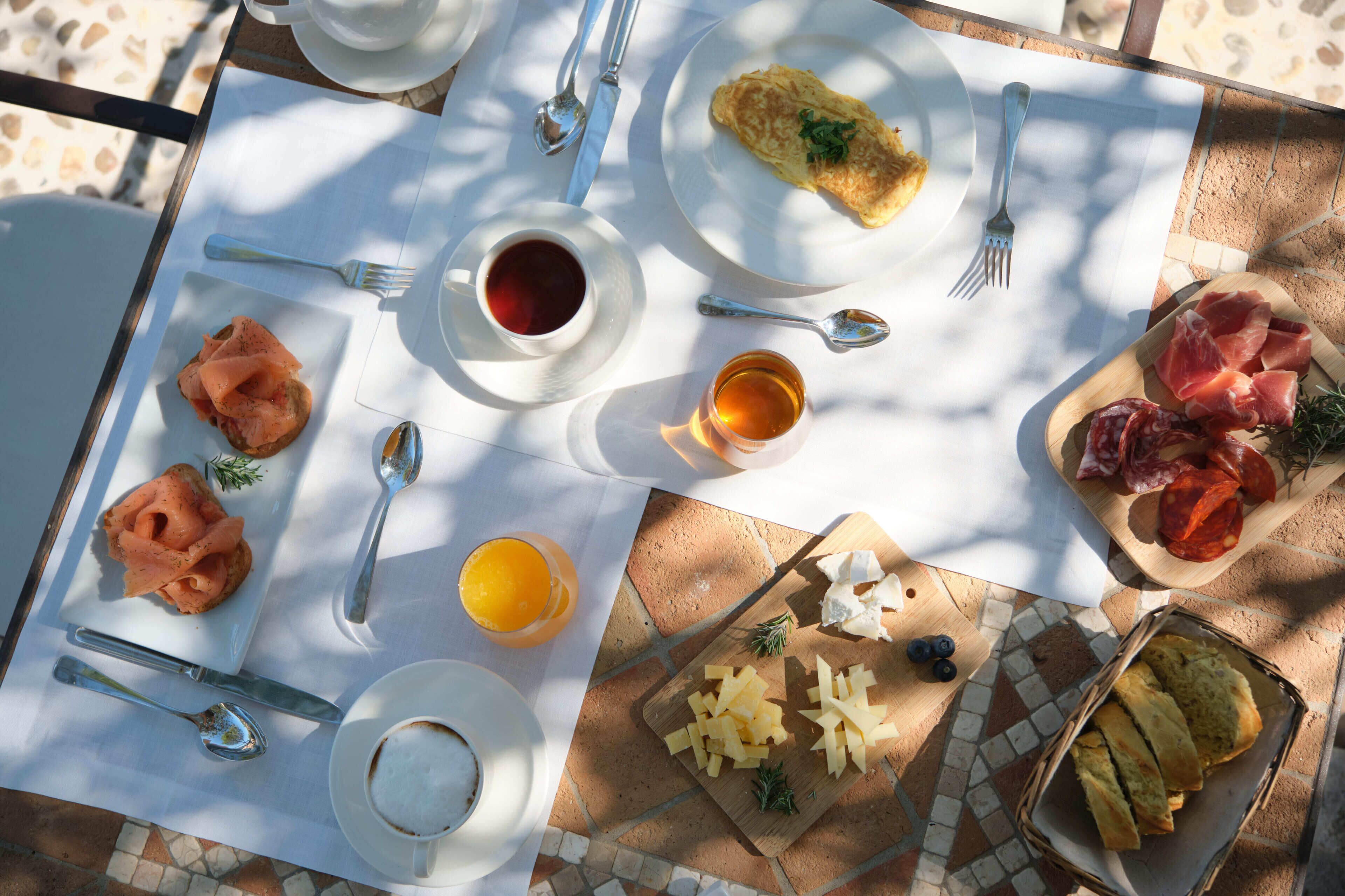 A breakfast setting with a variety of food items and utensils on a table.