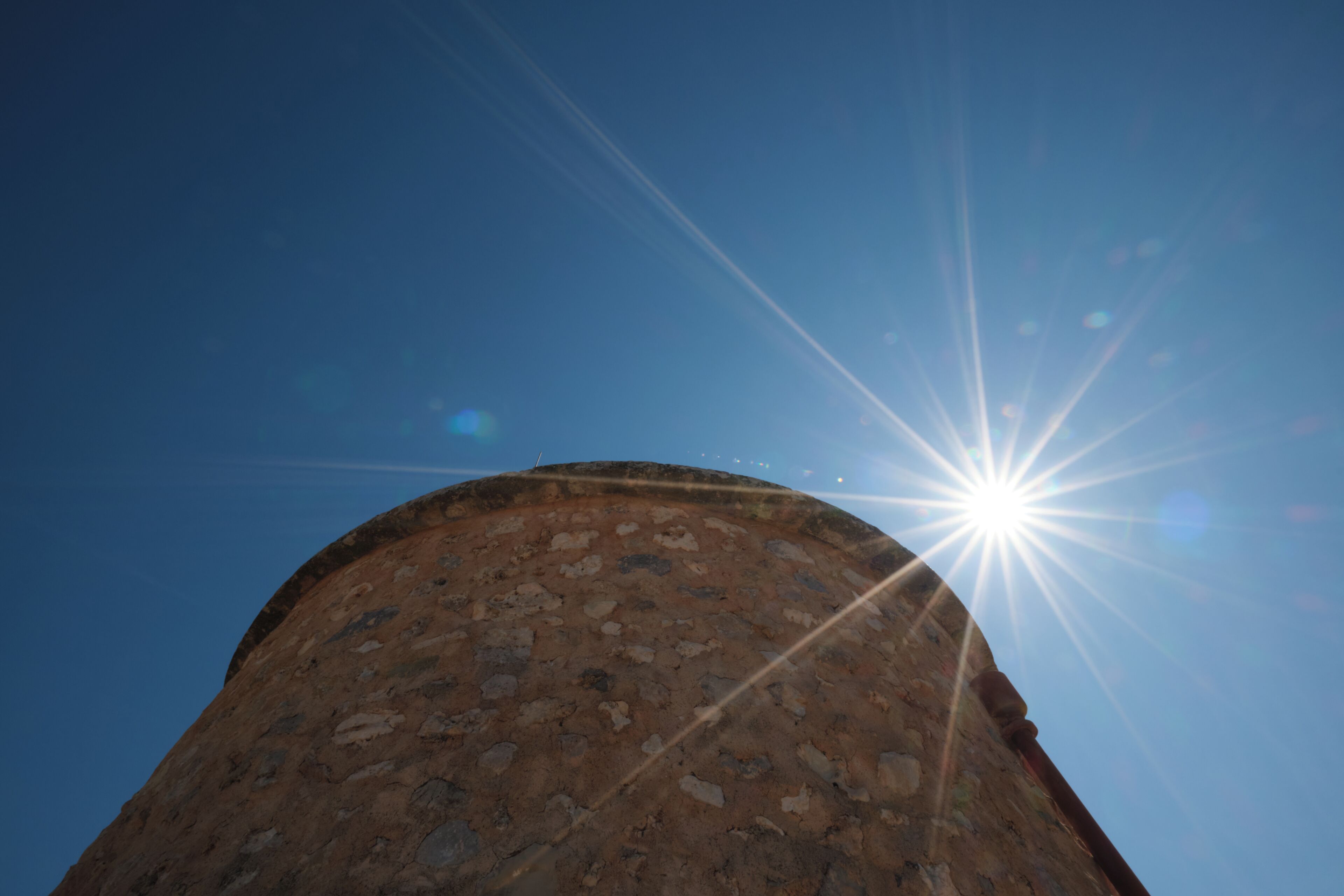 A circular stone structure with a clear sky in the background.